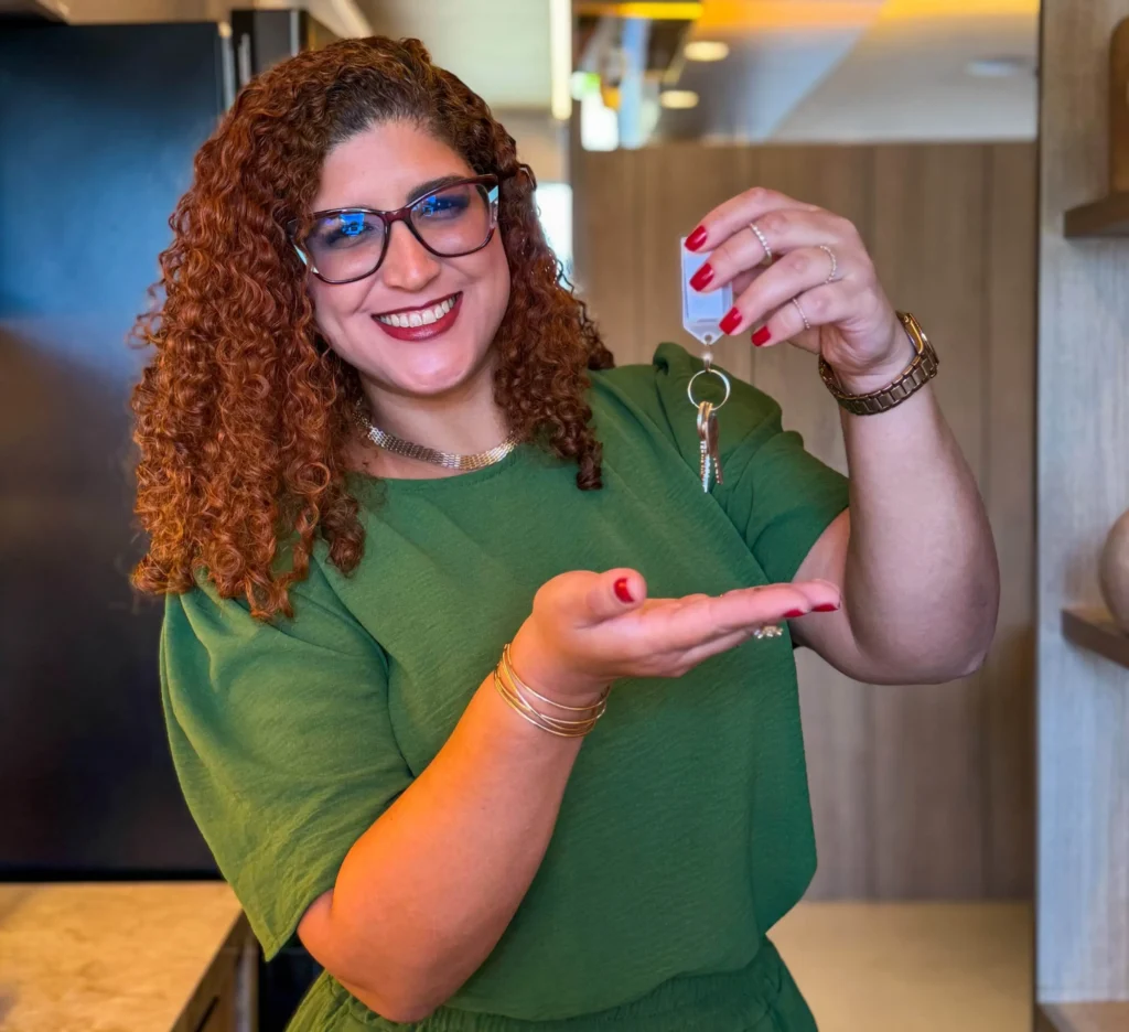 Corretora Thay segurando mostrando uma chave